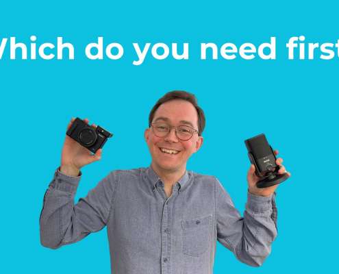 Simon holding a camera and a microphone asking "which do you need first?"